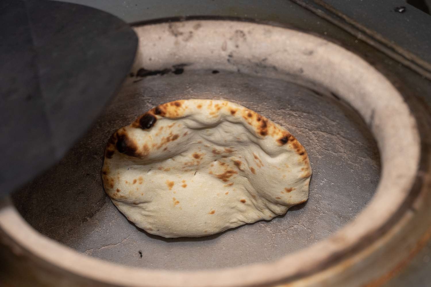 Tandoori Naan Baking Fresh naan bread being cooked inside a trad